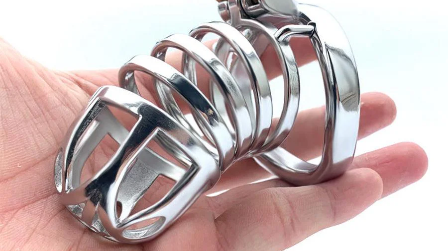 Male chastity cage in woman's hand